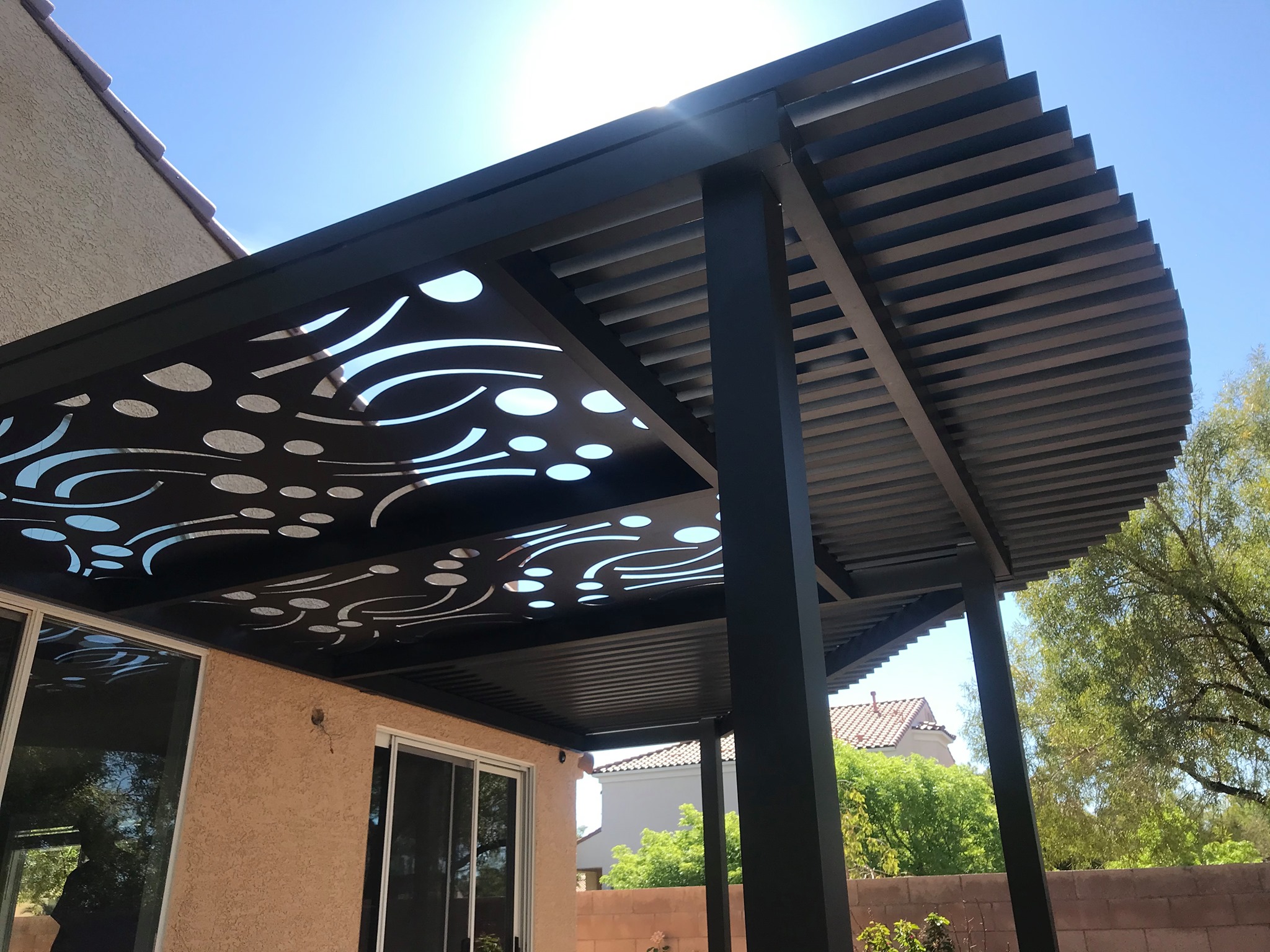 Decorative Soleil panels beside trellis sections in an aluminum patio cover