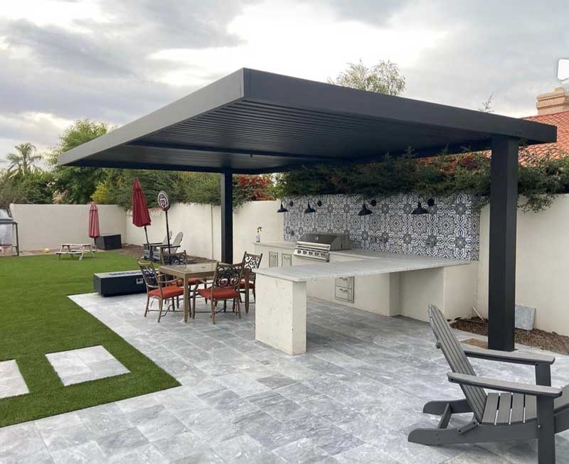 Dark gray 4K Aluminum cantilever patio cover over an outdoor kitchen and dining table on a stone patio