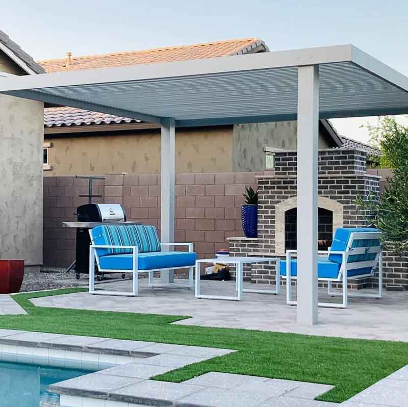 White 3-post cantilever aluminum patio cover over lounge chairs beside a backyard pool